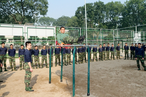Giáo viên của học viện làm mẫu cho học viên trong một buổi huấn luyện thể lực.
