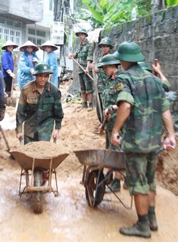 Cán bộ, chiến sĩ Tiểu đoàn 14, Sư đoàn 395 giúp nhân dân phường Hồng Hà, TP. Hạ Long nạo vét bùn đất trên đường liên khu.