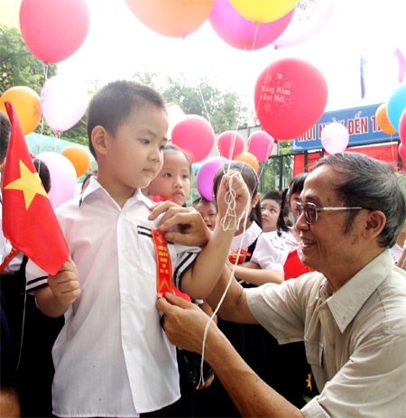 Ngày đầu vào lớp 1, cháu được ông chỉnh lại trang phục cho thật đẹp