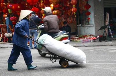 Mặc áo mưa là giải pháp mà nhiều người dân lao động lựa chọn để chống lại cái rét