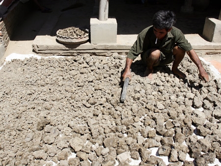 Đất sét lấy ngoài đồng ruộng về đập nhỏ, phơi khô và chộn thêm cát trước khi tạo hình