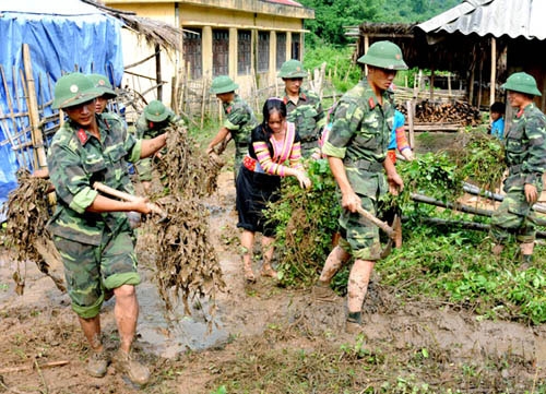Các chiến sĩ Tiểu đoàn 6 và thanh niên trong xã dọn vệ sinh thôn bản