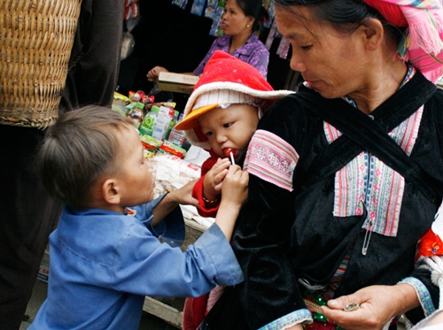 Hai anh em người Mông ở chợ phiên Dào San (Lai Châu) chung nhau niềm vui qua chiếc kẹo mút