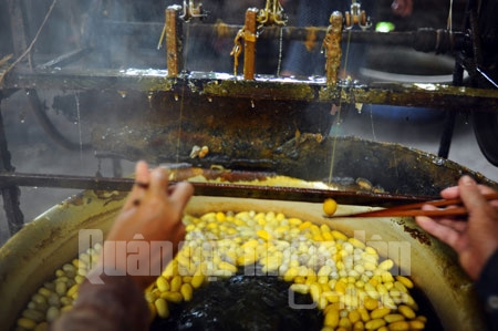 Kén được nấu trong những nồi nước sôi và khuấy liên tục. Đây là công đoạn khá cực nhọc của nghề kéo kén