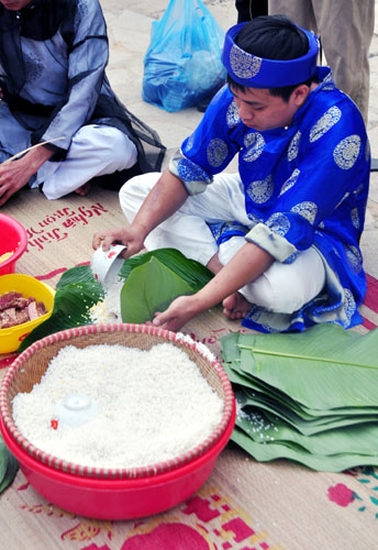 Công đoạn đầu tiên là rải lá và đong gạo đủ lượng làm nên chiếc bánh.