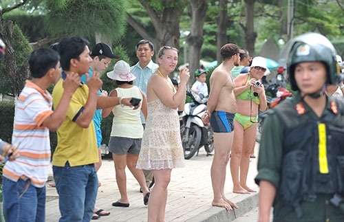 Nhiều du khách nước ngoài bỏ tắm biển lên xem đoàn đua về đích.