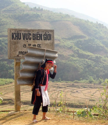 Cô gái Dao vui cười đón nhận tấm lợp về làm nhà