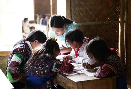 Cô giáo dạy chữ cho trẻ em