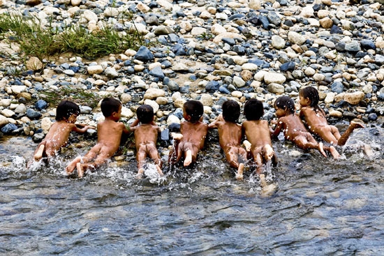 Những đứa trẻ tự học bơi bên bờ suối cạn