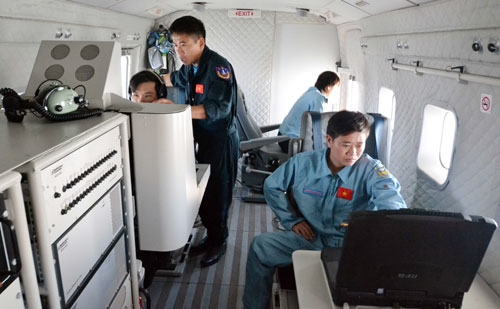 Các thành viên của trên máy bay CASA-212 đang thực hiện nhiệm vụ ghi lại những hình ảnh trên biển.