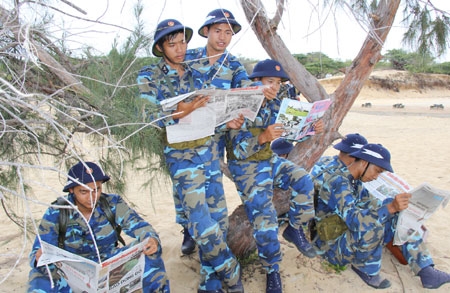 Cán bộ, chiến sĩ cùng đọc báo trong giờ nghỉ giải lao.