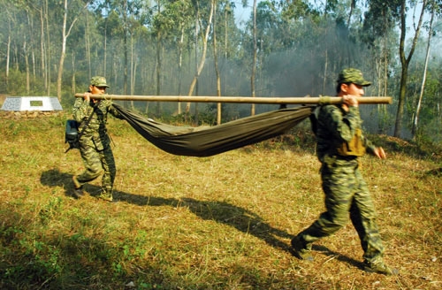 Tiến hành vận chuyển “thương binh” về các tuyến quân y bằng võng.