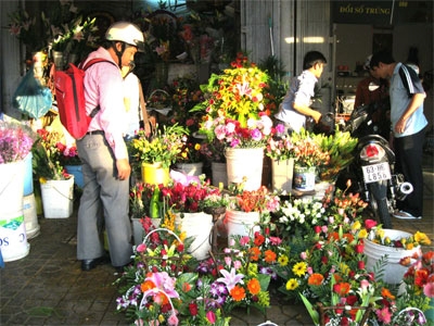 Một chàng trai đang chọn mua hoa tặng người thân nhân dịp 8-3