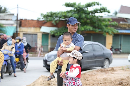Nhiều phụ huynh bồng bế con ra đường xem đoàn đua.