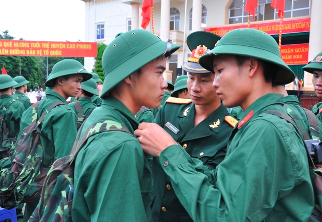 Những thanh niên ưu tú của địa phương được chỉ huy đơn vị nhận quân giúp đỡ công việc mới mẻ - đeo quân hàm.